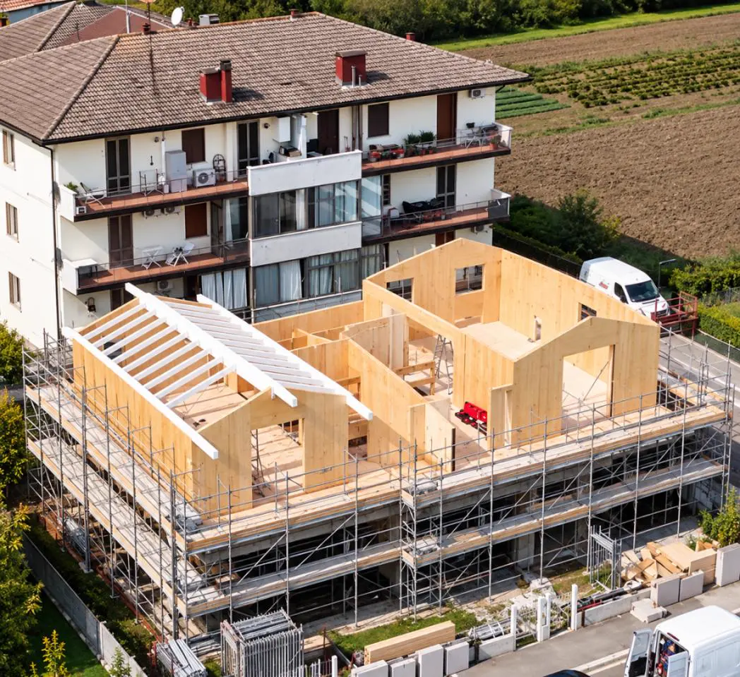 CLT wall panels and timber roof beams during construction of an XLAM Dolomiti floor addition in Rimini, Italy